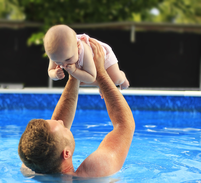 water safety rules for parents - a dad holds his baby in the pool