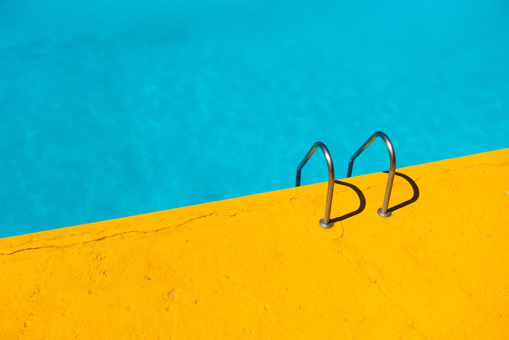 summer during the pandemic guidelines - yellow pool deck and water  