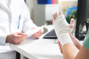 Picture of a doctor talking to a patient with a bandaged hand.